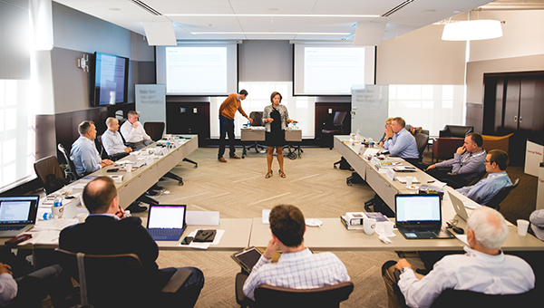 A classroom of executives listening to an instructor