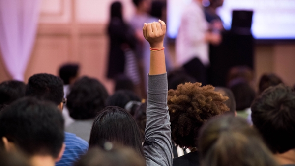 Student raising hand in a classroom setting