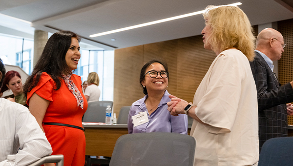 Three women chat during an Executive Advantage event.