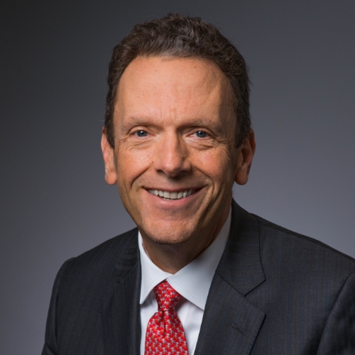 David Holmberg head and shoulders image. David is smiling and wearing a dark gray suit jacket and red patterned tie.