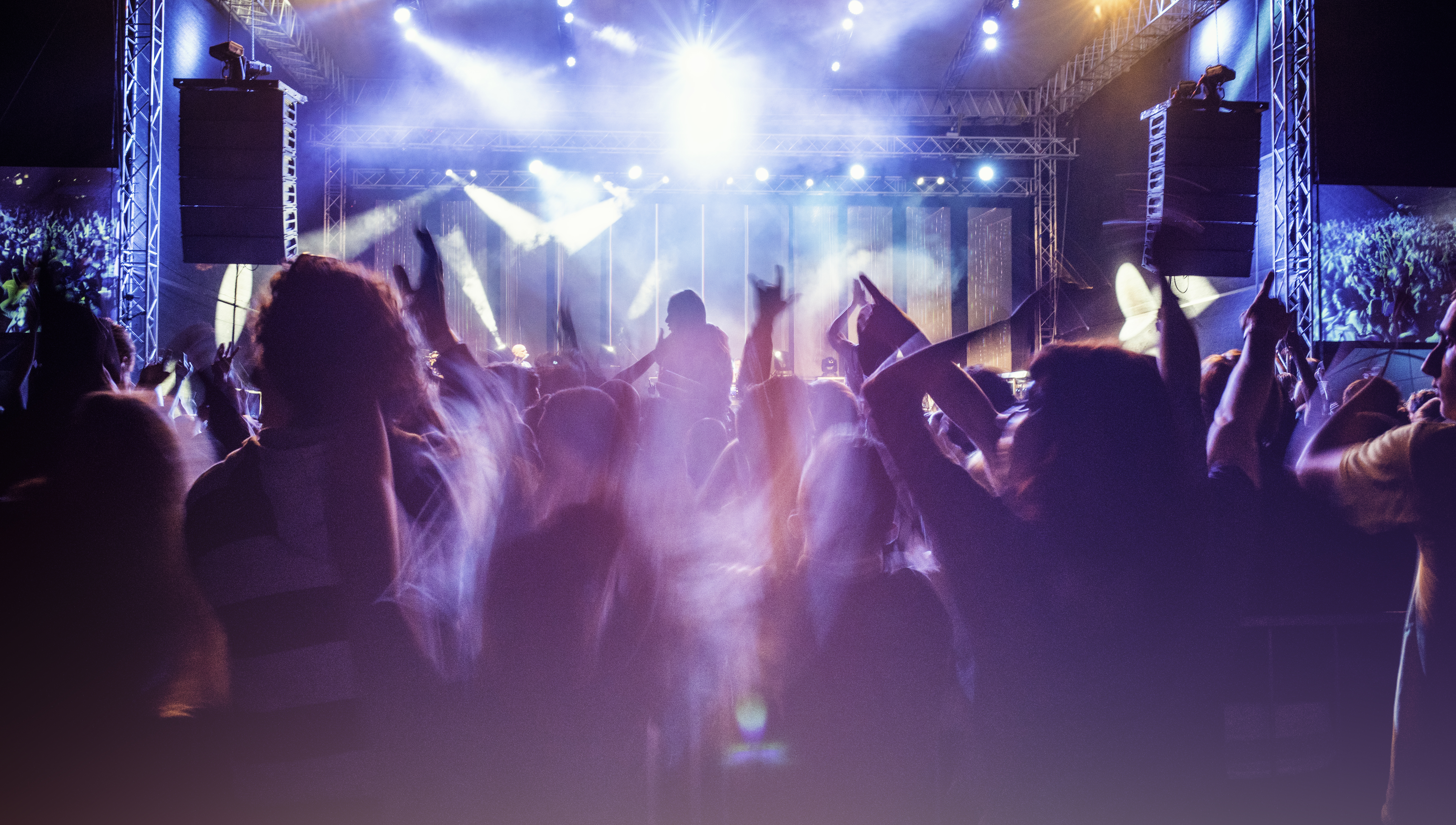 People dancing at a club to a DJ spinning records