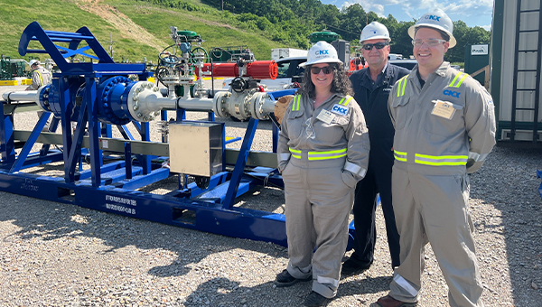 Abby Smith and colleagues stand in front of a blue machine.