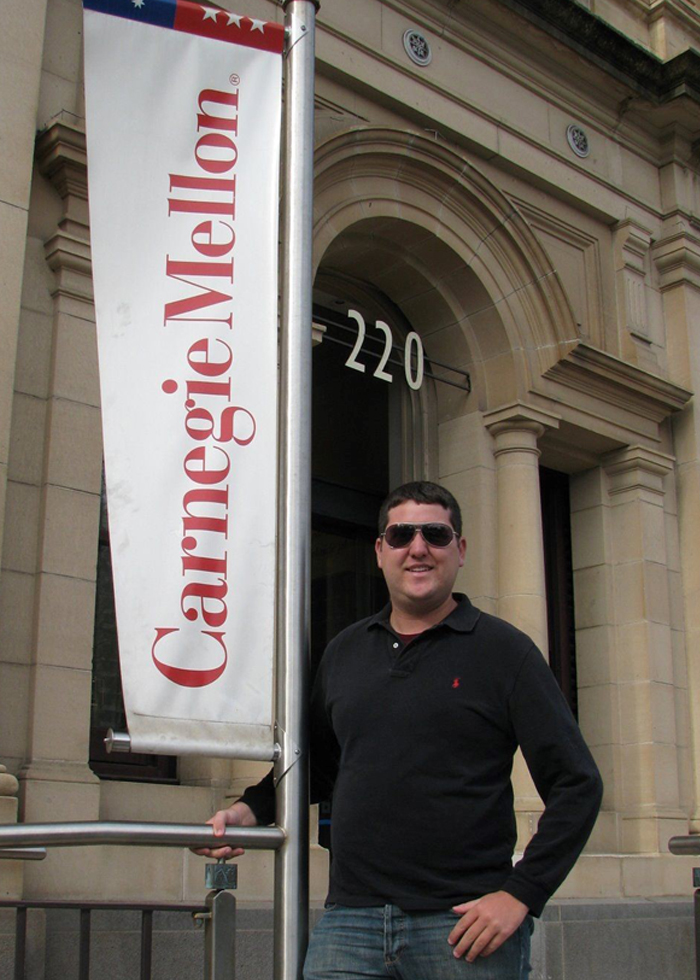 Alan Eaton stands next to a Carnegie Mellon banner at CMU in Australia in 2008.