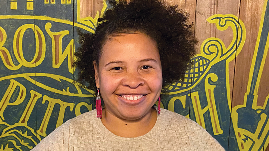 image of Danele Hughson in front of a sign that reads Grow Pittsburgh