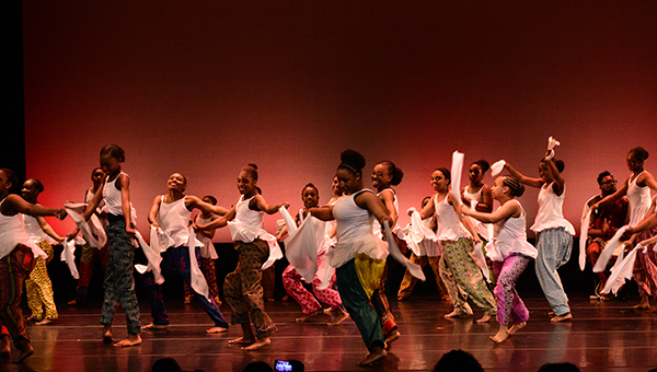 image of children dancing on stage in a large group