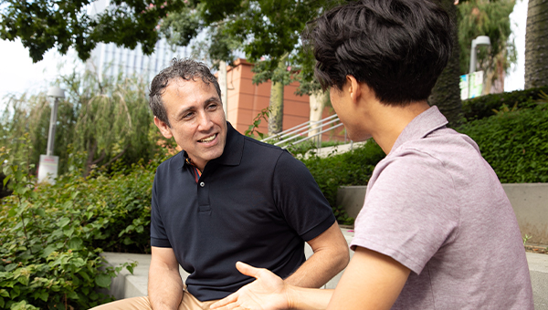 Samir Bitar sits and talks with someone from his Los Angeles district.