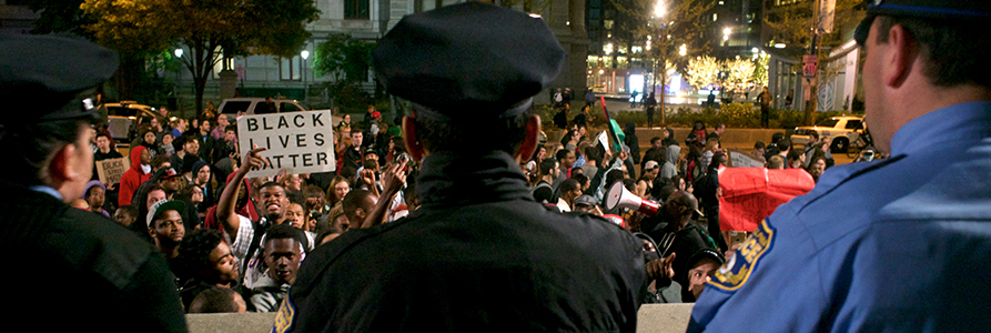 Police officers stand in front of a Black Lives Matter protest