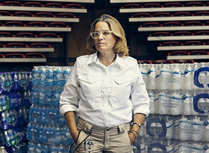 Carmen Yulin Cruz in front of palettes of water