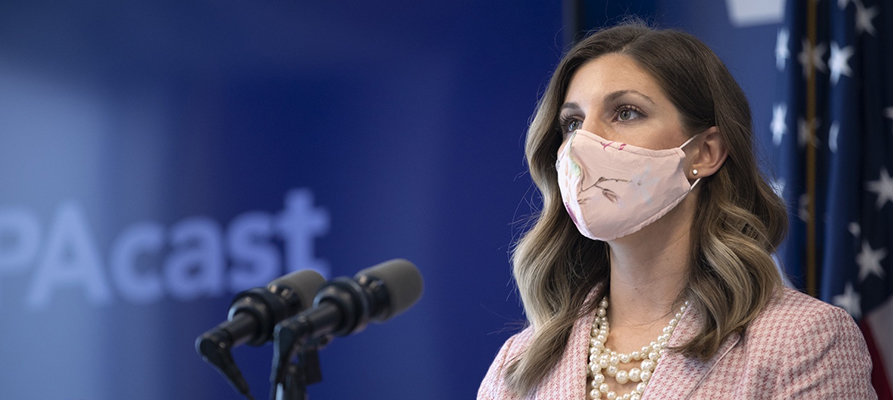 image of alumna Keara Klinepeter speaking during a press conference in Harrisburg. Se stands behind a podium with a protective mask.