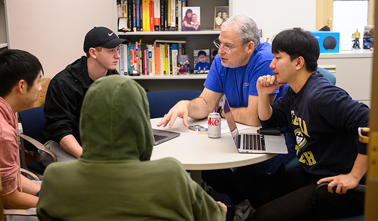 Larry Heimann meets with students in his office.