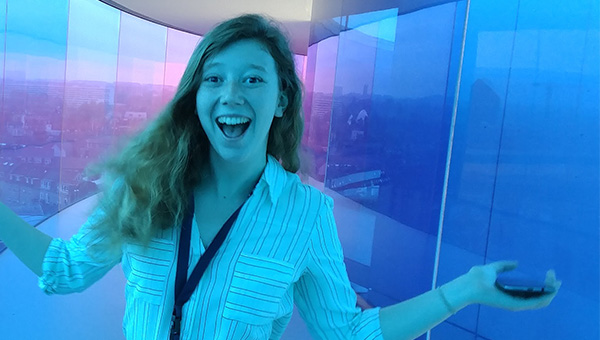 A female student smiling at a conference in Denmark